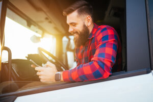 Young,Handsome,Bearded,Man,Using,Smart,Phone,In,His,Truck.
